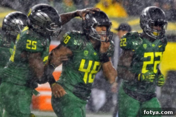 Καλή ποδοσφαιρική σεζόν 3 Παίκτες των Oregon Ducks σε βρεγμένο γήπεδο