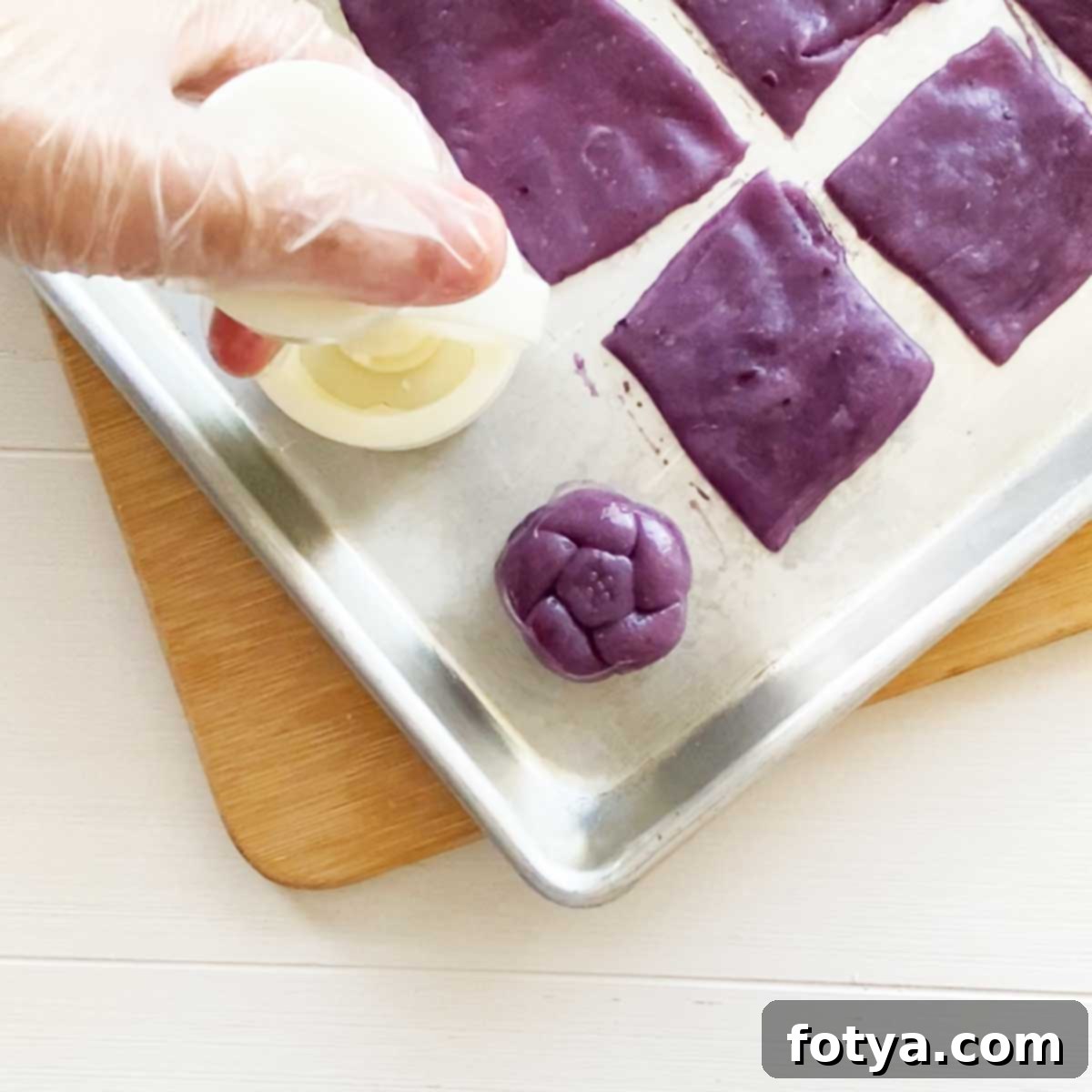 Ube Χιονάτες Φεγγαρόπιτες: Υγιεινές, Βίγκαν & με Λίγες Θερμίδες 10 Διαμόρφωση των γεμιστών κομματιών ζύμης με ένα καλούπι φεγγαρόπιτας.